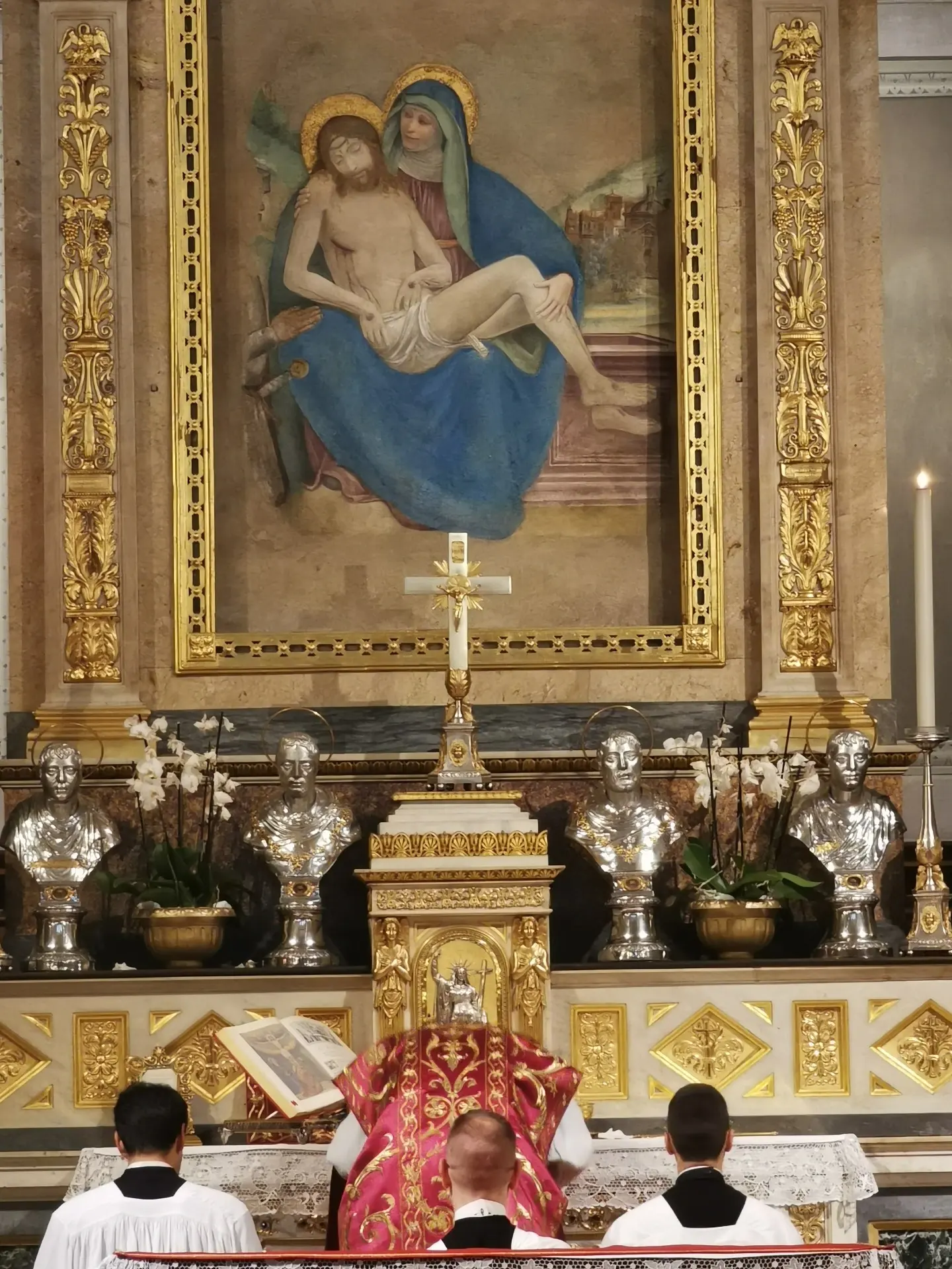immagine del prete e sacerdoti inchinati all'altare